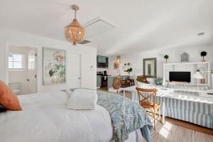 a white bedroom with a bed and a living room at Crawford Carriage House in Savannah