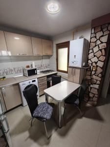 a small kitchen with a table and chairs and a counter at Sunset Home Apartment in Galaţi
