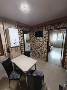 a kitchen with a table and chairs and a refrigerator at Sunset Home Apartment in Galaţi +3 photos