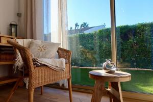 a chair and a table in a room with a window at Lora Apartment with Garden & Pool in Mandelieu-La Napoule