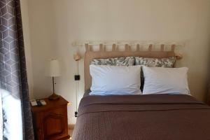 a bedroom with a bed with two pillows and a lamp at Lora Apartment with Garden & Pool in Mandelieu-La Napoule +15 photos