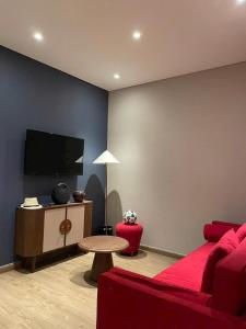 a living room with a red couch and a tv at Apec Mandala Sea View Bathtub by MLT in Mui Ne