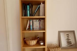 a book shelf filled with books and a basket at Lora Apartment with Garden & Pool in Mandelieu-La Napoule