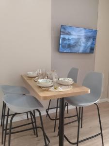 a dining room table with chairs and a painting on the wall at WOODSPACE Apartment in Shchūchīnsk