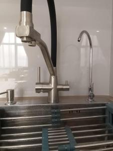 a kitchen sink with a faucet on top of it at WOODSPACE Apartment in Shchūchīnsk