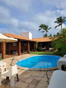 a villa with a swimming pool and a house at Pousada Brisa do Oceano - Cumbuco in Cumbuco +18 photos
