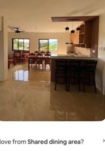 a kitchen and dining room with a bar with chairs at Yalyn's Hometel Kabankalan in Kabankalan