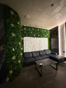 a living room with a couch and a green wall at Fidji Hotel in Yerevan