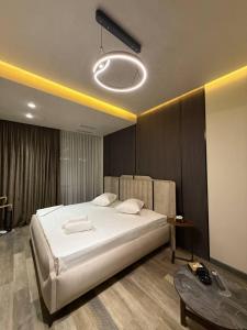 a bedroom with a large white bed and a table at Fidji Hotel in Yerevan