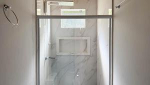 a shower with a glass door in a bathroom at Sítio D Ouro in Marechal Floriano +21 photos