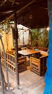 a patio with a wooden table under a pavilion at GoArize by Rootsvilla Vagator in Anjuna