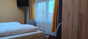 a bedroom with a bed and a window with yellow curtains at Ferienhaus Mond mit Sternenblick in Lochow +8 photos