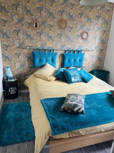 a bedroom with a bed with blue pillows at Guedon sandrine in Grosley-sur-Risle