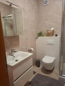 a bathroom with a white sink and a toilet at Terrace Apartmani in Široki Brijeg +32 photos
