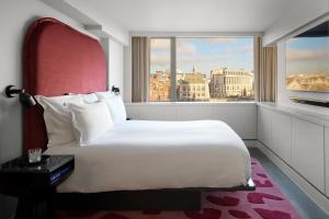 a bedroom with a large white bed and a window at Sea Containers London in London