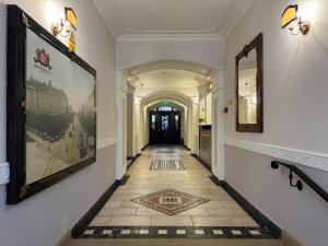 a hallway with a tile floor and paintings on the walls at Hotel Iosefin Residence in Timişoara