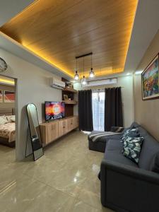 a living room with a couch and a tv at Yalyn's Hometel Kabankalan in Kabankalan