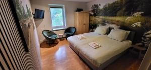 a bedroom with a bed and a desk and a window at Herberg De Eexter Os in Eext