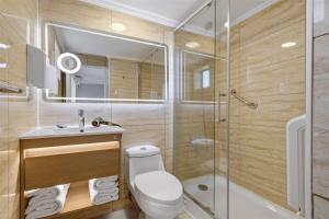 a bathroom with a shower and a toilet and a sink at Isabel Suites Vitacura in Santiago +106 photos