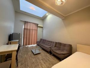 a living room with a couch and a television at DeltaHotel in Ureki