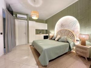 a bedroom with a large bed with a green blanket at Aura Suites Napoli in Naples