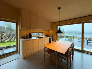 a kitchen with a wooden table and a large window at Architect-Designed Cabin By Lake With Sauna in Homle