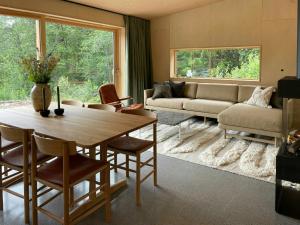 a living room with a table and a couch at Architect-Designed Cabin By Lake With Sauna in Homle