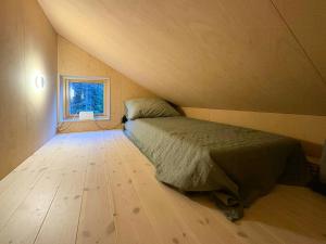 a small bedroom with a bed and a window at Architect-Designed Cabin By Lake With Sauna in Homle +24 photos