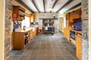 a large kitchen with wooden cabinets and a stone wall at Making Tracks Hostel in Portlaoise