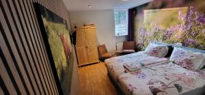 a bedroom with a bed and a painting on the wall at Herberg De Eexter Os in Eext +30 photos