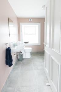 a bathroom with a white toilet and a sink at Making Tracks Hostel in Portlaoise
