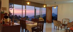 a dining room with a table and chairs with a view at Pekoe House in Galaha Town