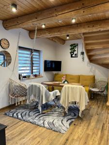a living room with a couch and a table at Domek w lesie Sauna i Gorąca balia Wellness&Spa in Grybów