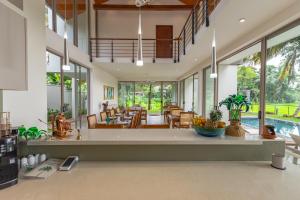 an open kitchen and living room with a pool at ONA Garden Villa in Galle