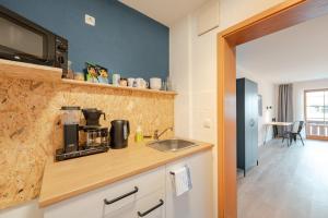 a kitchen with a sink and a microwave at Weitnau Stays - Hotel & Hostel in Weitnau