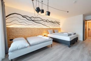 two beds in a bedroom with a mural on the wall at Weitnau Stays - Hotel & Hostel in Weitnau