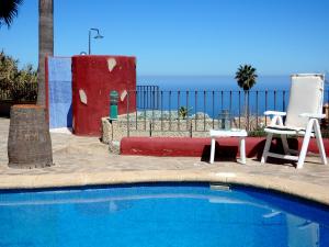 a swimming pool with a chair and a table and a chair at Finca La Chamusca in Icod de los Vinos