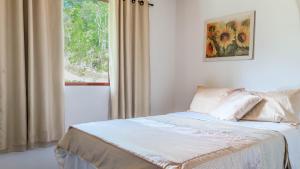 a bedroom with a bed and a window with curtains at Sítio D Ouro in Marechal Floriano