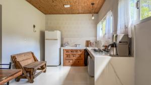 a kitchen with white appliances and a wooden table at Sítio D Ouro in Marechal Floriano