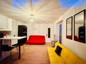 a living room with a yellow couch and a red seat at petit studio de bourgogne in Saint-Albain