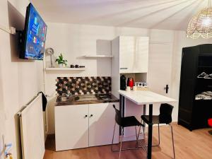 a kitchen with a counter and a table and chairs at petit studio de bourgogne in Saint-Albain