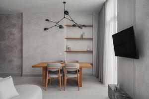 a dining room with a table and chairs and a tv at Luxury Suites by Lato in Agios Nikolaos
