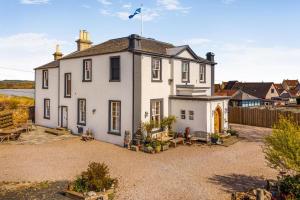 a white house with a flag on top of it at 4 Bed in Pittenweem oc-t35090 in Pittenweem