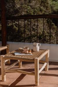 a wicker table and bench on a patio at Can Vistabella Boutique Resort in San Antonio