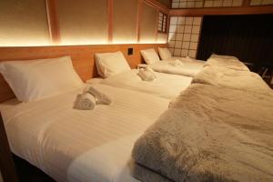 three beds in a room with white sheets and pillows at 侘然 - Wabizen - in Ikeda +29 photos