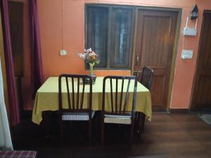 a dining room table with a vase of flowers on it at Gharonda in Dehradun