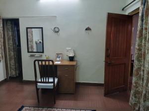 a room with a desk and a chair and a mirror at Gharonda in Dehradun +1 photo