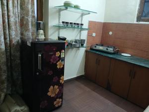 a kitchen with a refrigerator with flowers on it at Gharonda in Dehradun