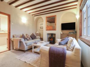 a living room with two couches and a fireplace at Little Launde Cottage in Leicester