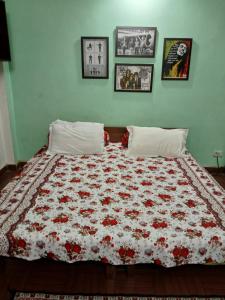 a bed with a red and white quilt on it at Gharonda in Dehradun